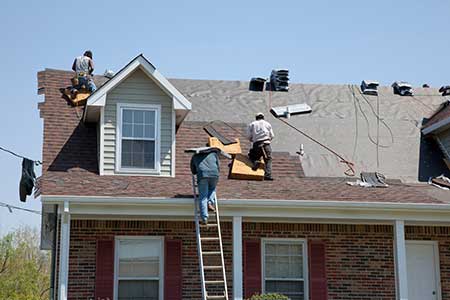 HartHaus Homes images - workers installing new red-ish, brown shingles on a residential roof